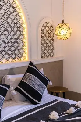 a bedroom with a bed with a window and a lamp at Riad DAR ELMA NOI in Marrakech