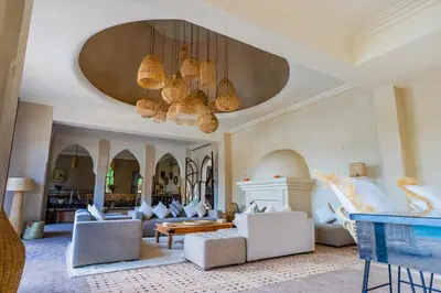 a living room with couches and a chandelier at Villa des SONGES in Marrakech