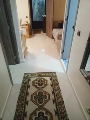 a hallway with a rug on a tile floor with a doorway at Logement Confort Résidence Fermée avec Piscine in Marrakech