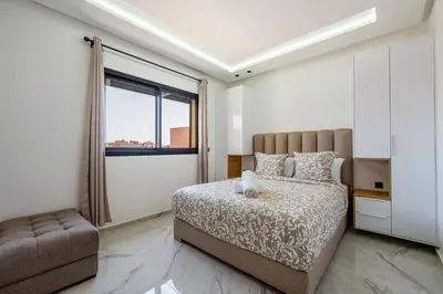 a bedroom with a bed and a chair and a window at Modern Studio in Hivernage with Pool Access in Marrakech