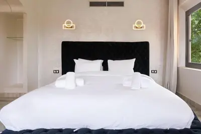a large white bed with white sheets and pillows at 4 Bed Villa lagune River Palm Marrakech with Pool in Marrakech