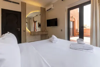a bedroom with a large white bed with towels on it at 4 Bed Villa lagune River Palm Marrakech with Pool in Marrakech