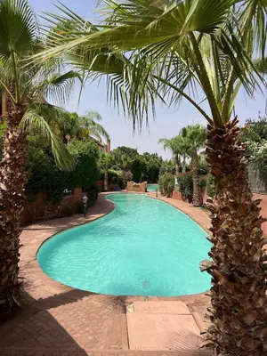 a large swimming pool with palm trees in a yard at 4 Bed Villa lagune River Palm Marrakech with Pool in Marrakech