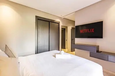 a hotel room with a bed and a tv on the wall at Spacious luxury 3BR by the pool in Marrakech