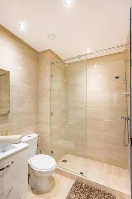 a bathroom with a toilet and a glass shower at Spacious luxury 3BR by the pool in Marrakech