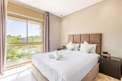 a bedroom with a large bed with a large window at Spacious luxury 3BR by the pool in Marrakech