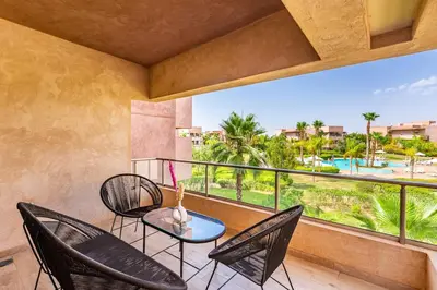 a balcony with chairs and a table and a view at Spacious luxury 3BR by the pool in Marrakech