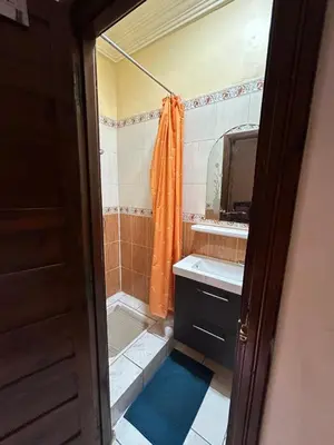 a bathroom with an orange shower curtain and a sink at Riad Marrakech in Marrakech