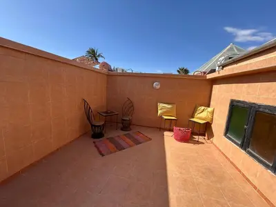 a patio with chairs and tables on a building at Riad Marrakech in Marrakech