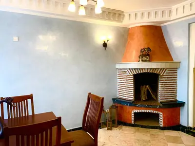 a living room with a fireplace with a table and chairs at Appartement Marrakechi in Marrakech