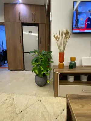 a living room with a potted plant and a tv at Berber Atlas Marrakech with Pool in Marrakech
