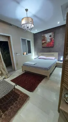 a bedroom with a bed and a chandelier at nice apartment and good location in Marrakech