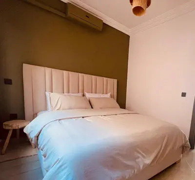 a bedroom with a large white bed and a chair at Bright Place and High Quality Mattress in Marrakech