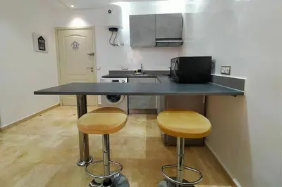 a kitchen with two bar stools and a counter top at Cozy Apt in Heart of Marrakech, Walk Everywhere in Marrakech