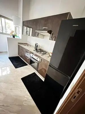 a kitchen with a stove and a refrigerator at Cozy apartment with a pool2 in Marrakech
