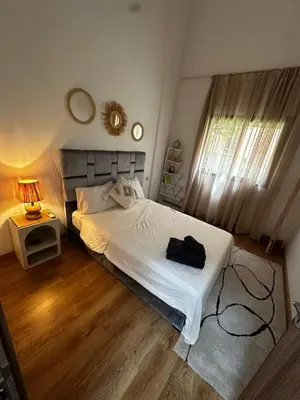 a bedroom with a bed with a black bag on it at Cozy apartment with a pool2 in Marrakech