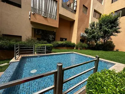 a swimming pool in a yard next to a building at Cozy apartment with a pool2 in Marrakech