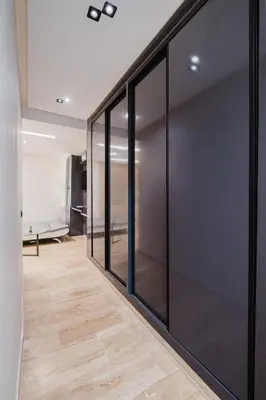 a hallway with black glass doors and a wooden floor at Cozy Appartement in the heart of Gueliz Marrakech in Marrakech