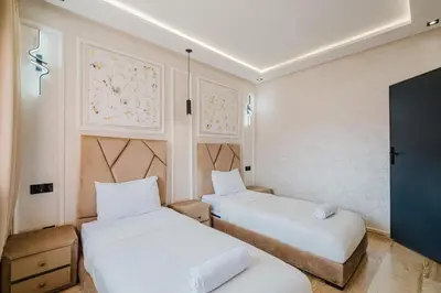 a room with two beds and a flat screen tv at Cozy Appartement in the heart of Gueliz Marrakech in Marrakech