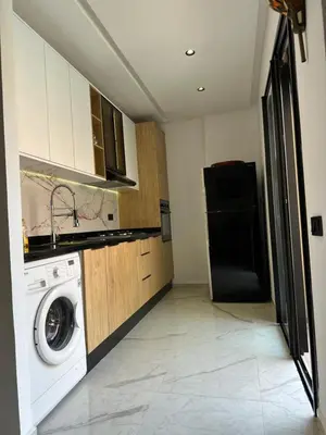 a kitchen with a washing machine and a refrigerator at Aube Hivernage appartement in Marrakech