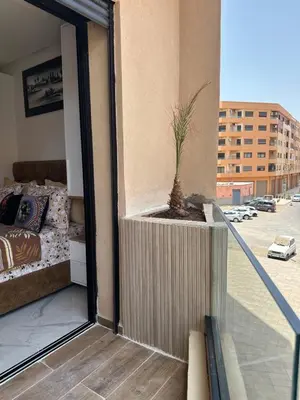 a potted plant sitting on the balcony of a building at Aube Hivernage appartement in Marrakech