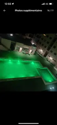 a view of a tennis court with green lights at Big confort in Marrakech