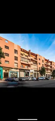 a large building with cars parked in front of it at Big confort in Marrakech