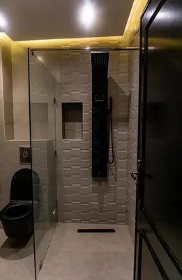 a bathroom with a glass shower with a toilet at Appartement Walili in Marrakech