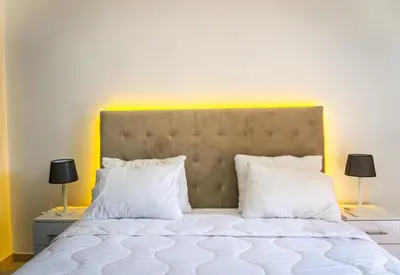 a bedroom with a bed with white pillows and two lamps at Appartement Walili in Marrakech