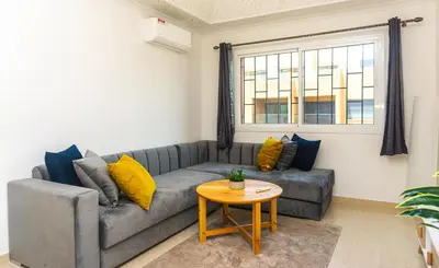 a living room with a gray couch and a table at Appartement Walili in Marrakech
