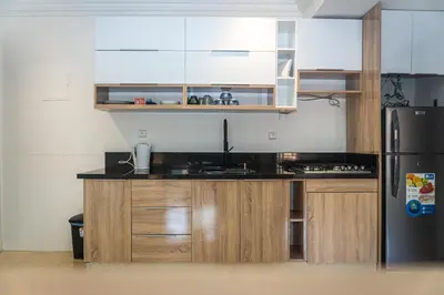 a kitchen with wooden cabinets and a black refrigerator at Appartement Walili in Marrakech