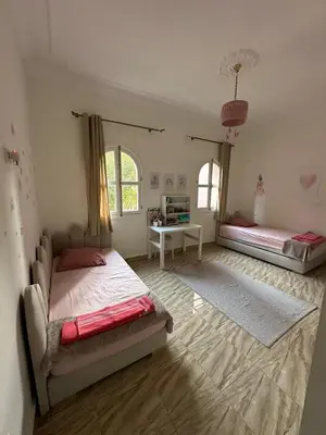 a bedroom with two beds and a desk in it at Villa Yasmine Marrakech in Marrakech