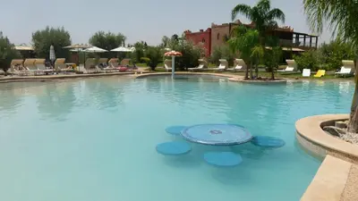 a large pool with blue water in a resort at Villa Yasmine Marrakech in Marrakech