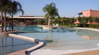 a large swimming pool with a fountain in a resort at Villa Yasmine Marrakech in Marrakech