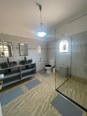 a bathroom with a toilet and two sinks and a shower at Villa Yasmine Marrakech in Marrakech