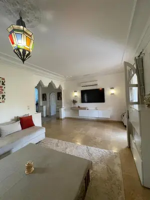 a living room with a couch and a flat screen tv at Villa Yasmine Marrakech in Marrakech