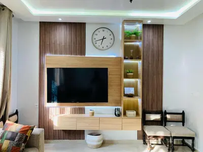 a living room with a television and a clock on the wall at 3 bedroom duplex with swimming pool in Marrakech