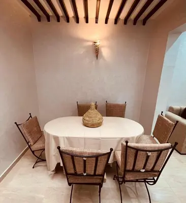 a dining room with a white table and chairs at 3 bedroom duplex with swimming pool in Marrakech