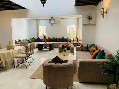 a living room with couches and chairs and a table at 3 bedroom duplex with swimming pool in Marrakech