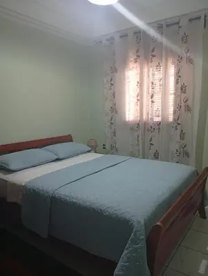 a bedroom with a bed and a window with curtains at appartement Airport Guests Marrakech in Marrakech