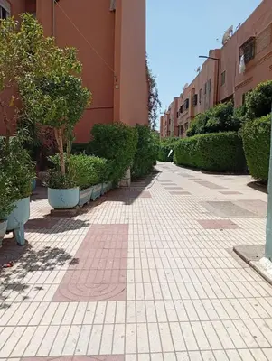 a sidewalk with trees and plants in a building at appartement Airport Guests Marrakech in Marrakech