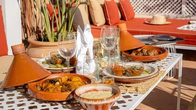 a table with plates of food and glasses of wine at Riad Dar Zioui in Marrakech