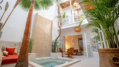 a living room with a pool and palm trees at Riad Dar Zioui in Marrakech