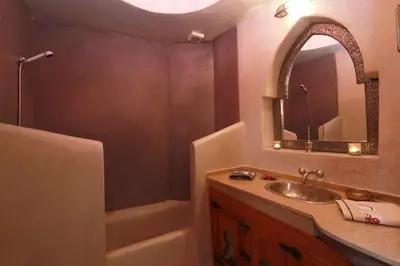 a bathroom with a sink and a tub and a mirror at Riad Khalid Zrika Marrakech in Marrakech