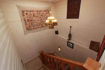 a staircase with a chandelier and a rug on the wall at Riad Khalid Zrika Marrakech in Marrakech
