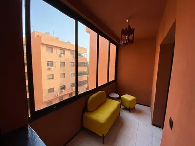 a room with a yellow chair and a window at Condominium in Marrakech