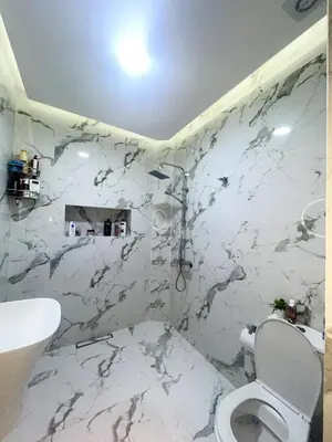 a bathroom with a toilet and a marble wall at Housna B&B Marrakesh in Marrakech
