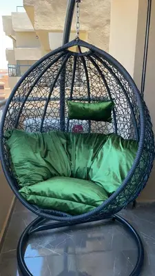 a hanging chair with a green cushion in a room at Appartement Haut de Gamme avec Piscine Privée et Grande Terrasse in Marrakech