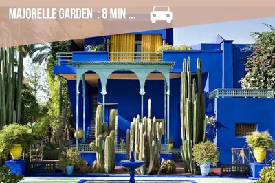 a blue building with cactus in front of it at Appartement Haut de Gamme avec Piscine Privée et Grande Terrasse in Marrakech