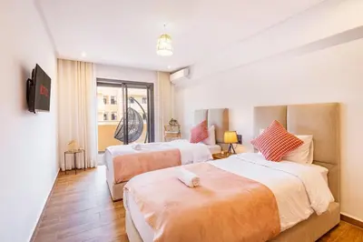 a hotel room with two beds and a window at Appartement Haut de Gamme avec Piscine Privée et Grande Terrasse in Marrakech